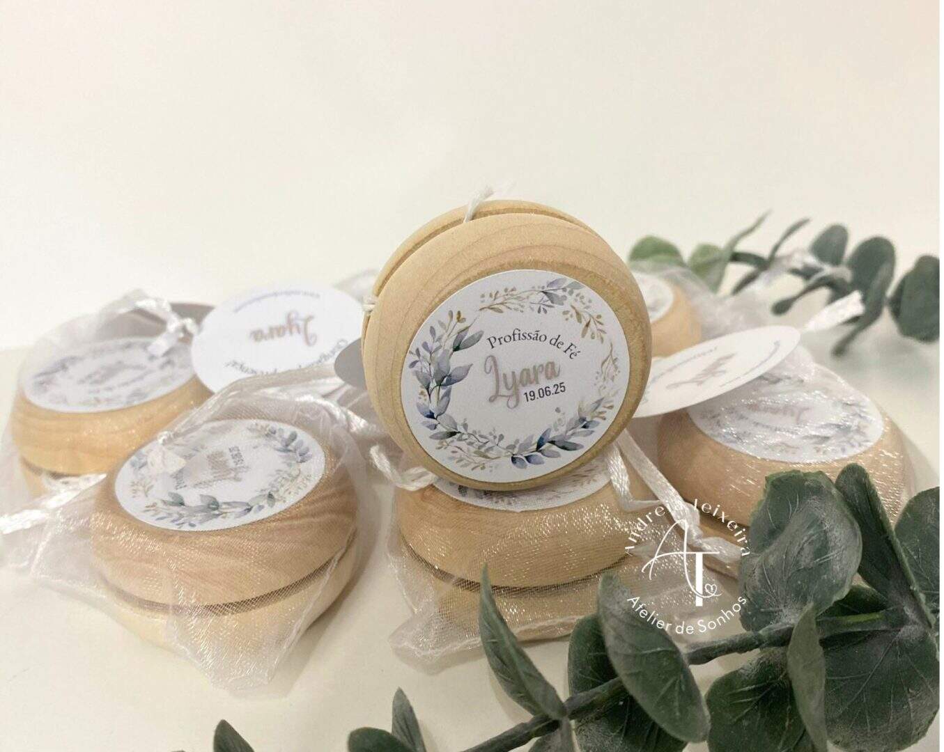 Conjunto de sabonetes artesanais embrulhados em plástico transparente, cada um com rótulo decorativo personalizado, ideal para presentes ou eventos especiais.