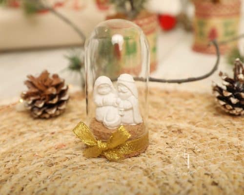 Guirlanda decorativa de Natal com bonecos de neve em vidro sob uma base de juta, decorada com fita dourada, ideal para enfeitar a casa na época natalícia.
