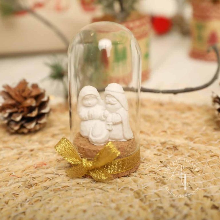 Guirlanda decorativa de Natal com bonecos de neve em vidro sob uma base de juta, decorada com fita dourada, ideal para enfeitar a casa na época natalícia.