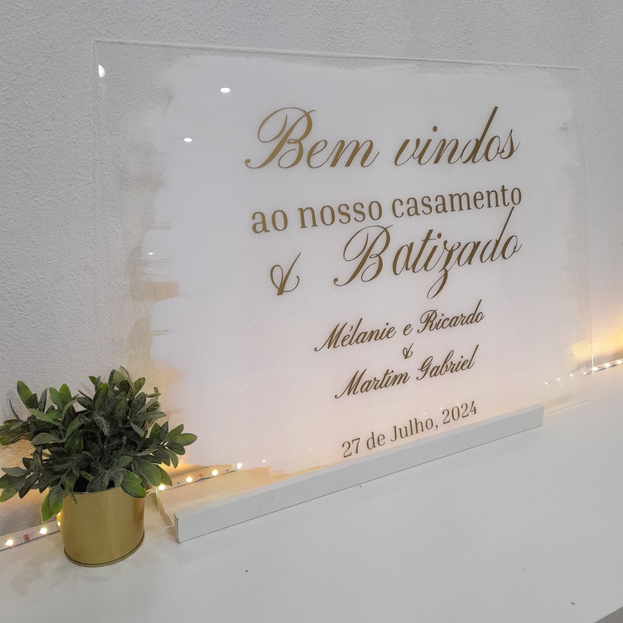 Placa acrílica de boas-vindas Coleção Luz 1 Placa acrílica de boas-vindas da Coleção Luz para casamento e batizado com fundo pincelado a branco e letras douradas.