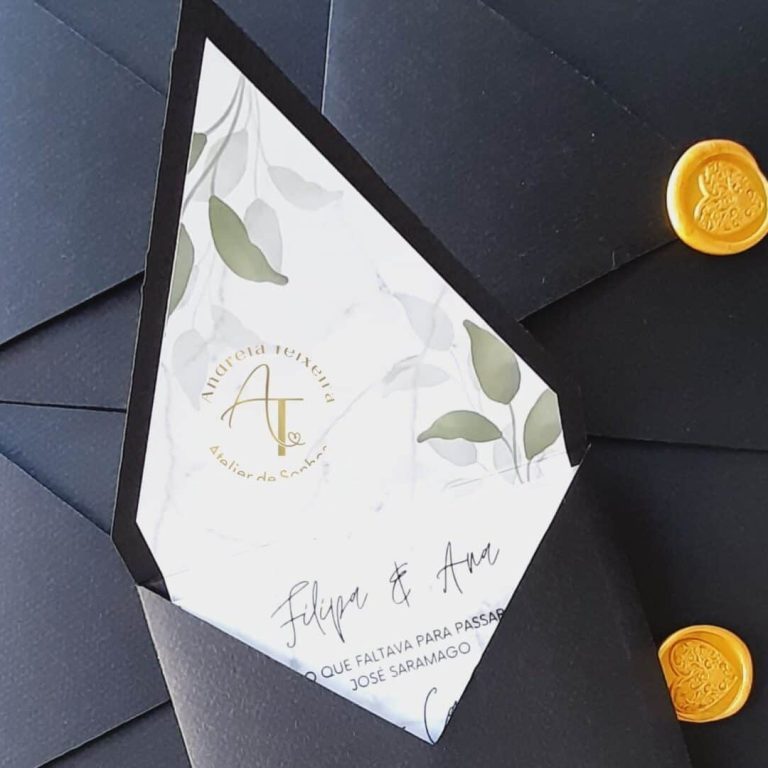 Convite de casamento com design floral e detalhes em dourado, acompanhado de envelopes pretos e selos dourados, ideal para ocasiões especiais.