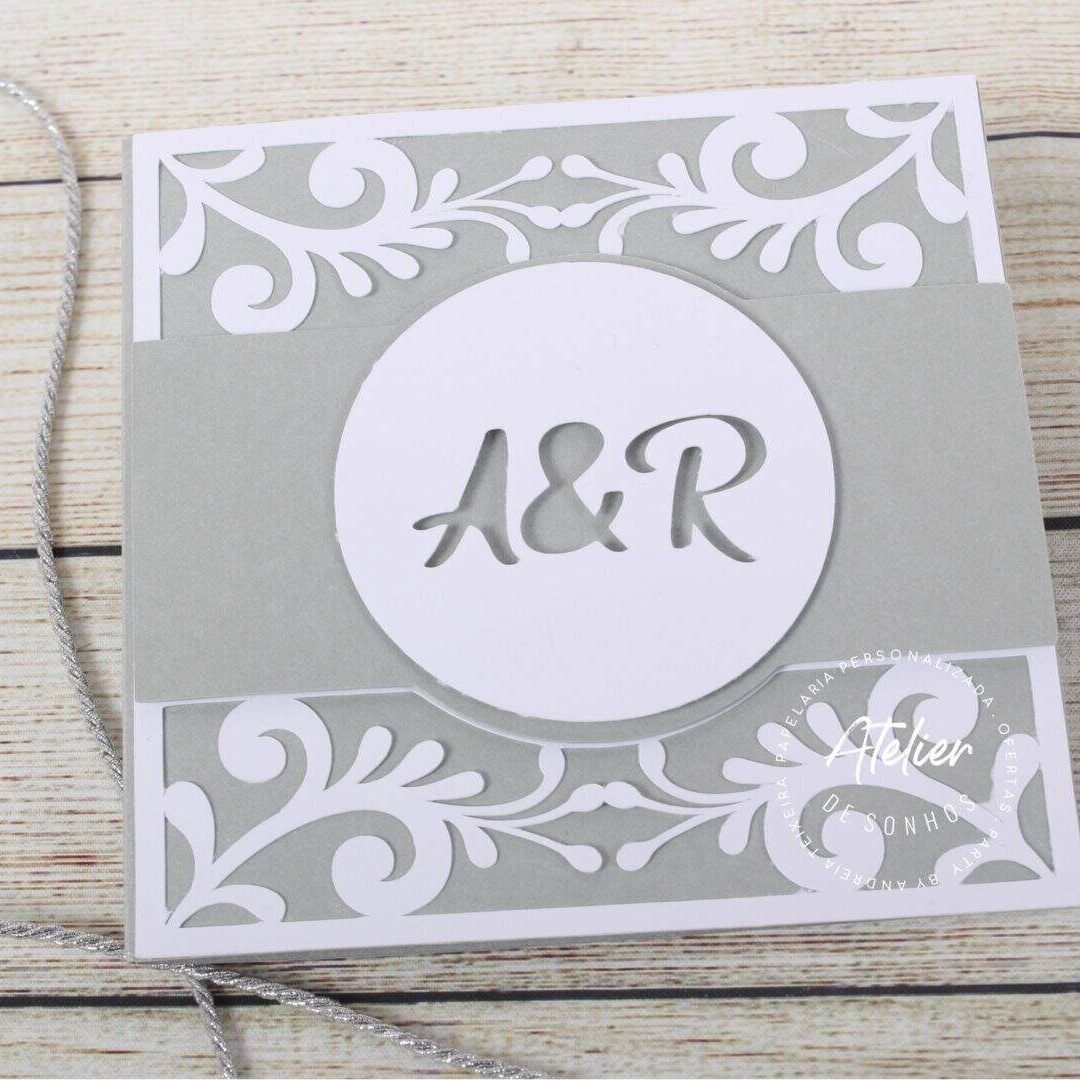 Capa de convite de casamento com detalhes em branco Convite de casamento com design elegante em tons de cinza e branco, apresentando as iniciais A&R em destaque no centro, com detalhes decorativos florais e uma corda para fechamento.
