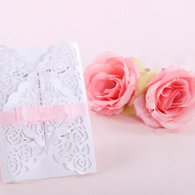 Cartão de convite de casamento com rosas cor-de-rosa. Cartão de convite de casamento delicado com detalhes de rosas e fita de cetim rosa, ideal para ocasiões especiais.