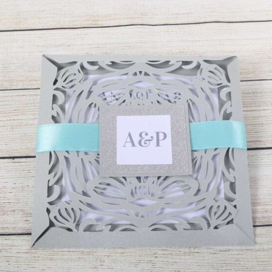 Convite de casamento com design delicado em papel com detalhes em laser e fita azul, ideal para ocasiões especiais e celebrações românticas.