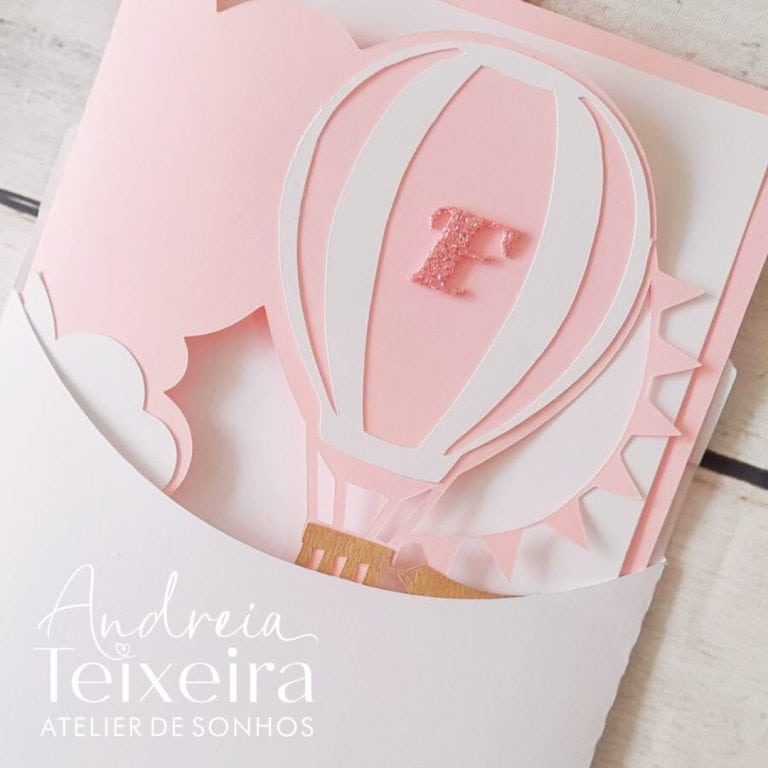 Ponte de papel em forma de balão de ar quente com detalhes em rosa e branco, ideal para decoração de festas ou convites personalizados.