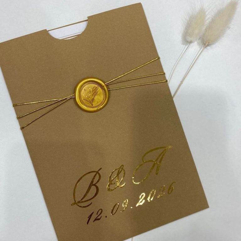 Cadeia de convites de casamento com detalhes dourados, incluindo uma fita e uma cera de selo, com a data 12.09.2026, em fundo dourado elegante.