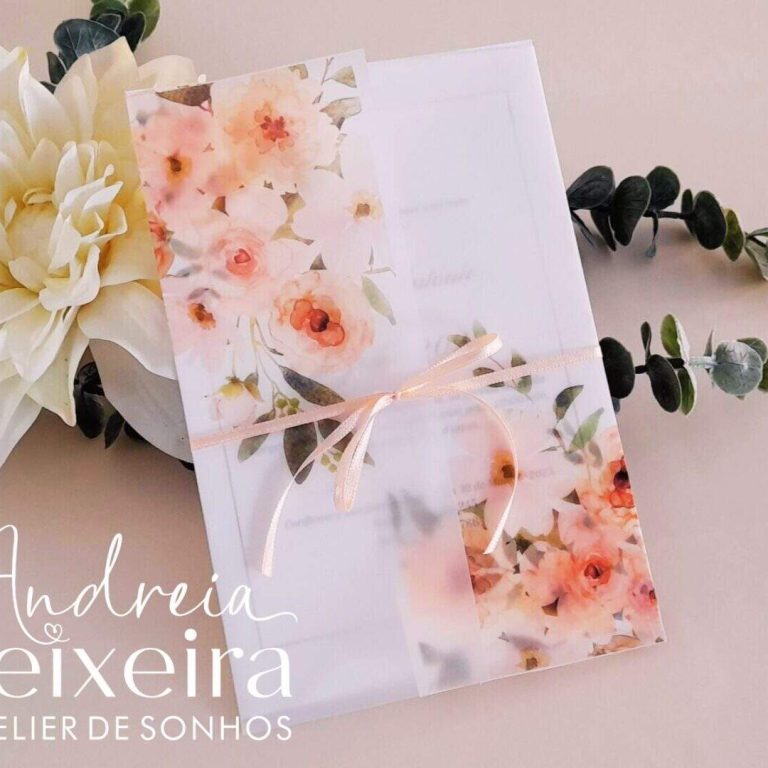 Largura de uma caixa de presente decorada com flores delicadas e fita de cetim, acompanhada por um ramo de folhagem verde escura, sobre fundo claro e suave.