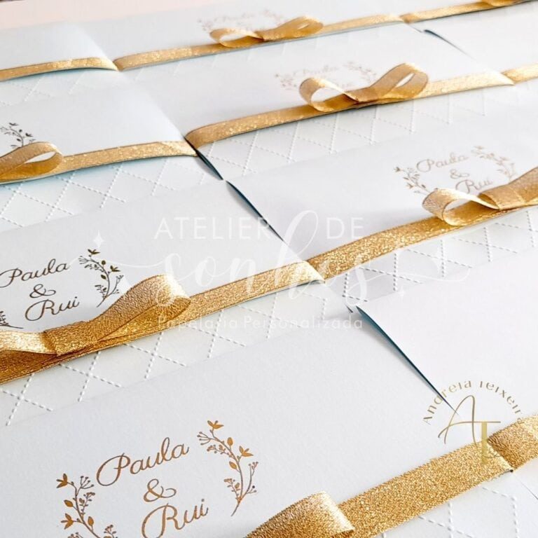 Fita dourada decorativa em envelopes de convite de casamento com nomes personalizados "Paula & Rui" em fonte elegante, ideal para ocasiões especiais e celebrações românticas.