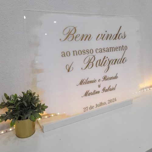 Placa acrílica de boas-vindas da Coleção Luz para casamento e batizado com fundo pincelado a branco e letras douradas.
