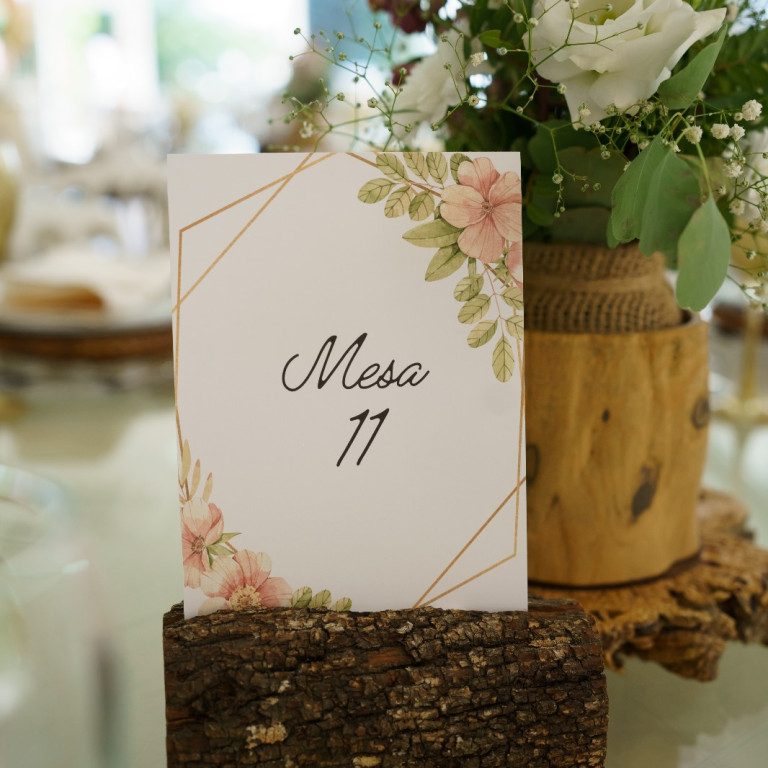 atelier de sonhos artigos de casamento estacionario (7) Cartaz de mesa com design floral e número 11, decorado com flores brancas e verdes em arranjo rústico de madeira.