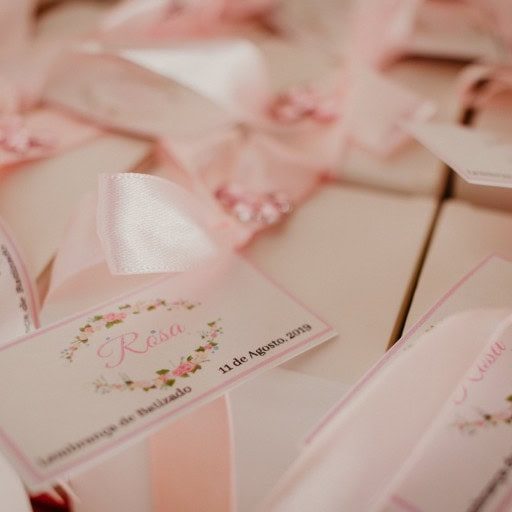 Lembranças de casamento com etiquetas personalizadas e detalhes em rosa, incluindo nomes e data do evento.