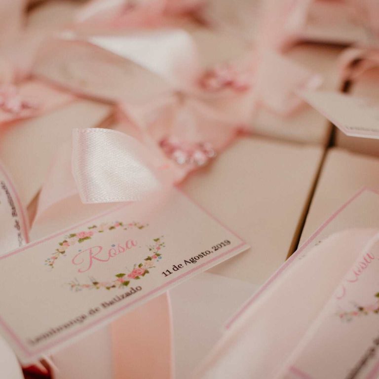 Lembranças de casamento com etiquetas personalizadas e detalhes em rosa, incluindo nomes e data do evento.