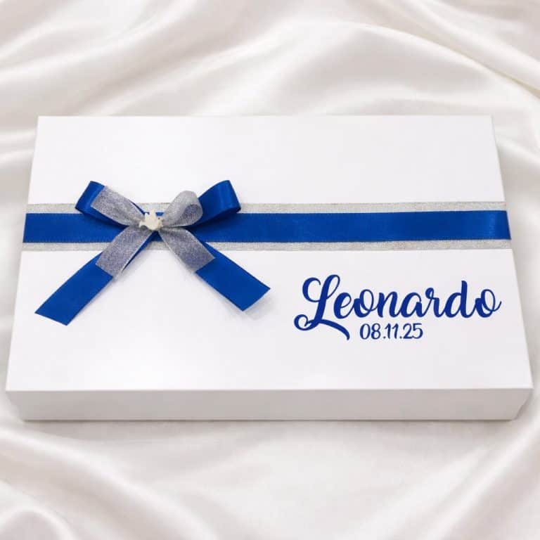 caixa batismo mdf atelier de sonhos 2 Cadeado branco com fita azul e cinza, personalizado com o nome "Leonardo" e a data "08.11.25" em uma caixa de presente elegante.