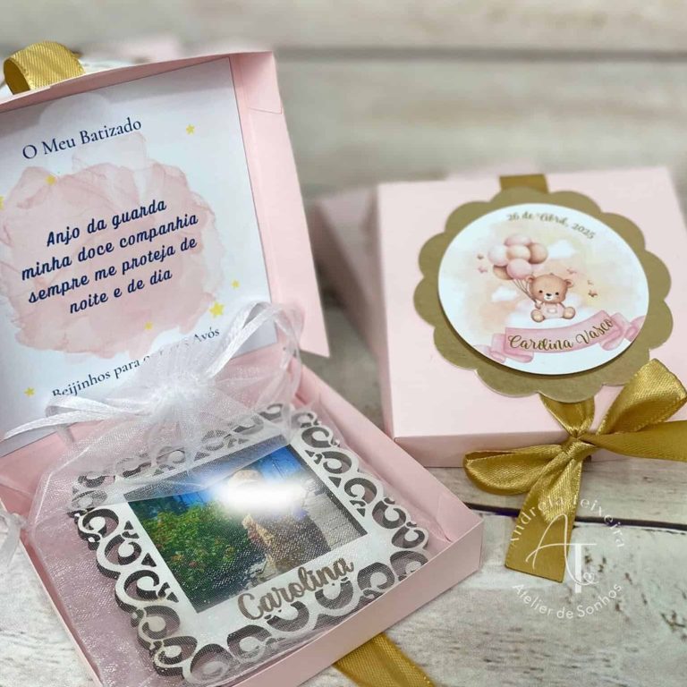 Caixa de lembrança de batizado com uma foto, mensagem e decoração delicada em tons de rosa, branco e dourado.