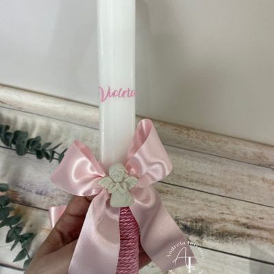 Vela de batismo personalizada para a Violeta com laço rosa e aplique de anjo em oração.
