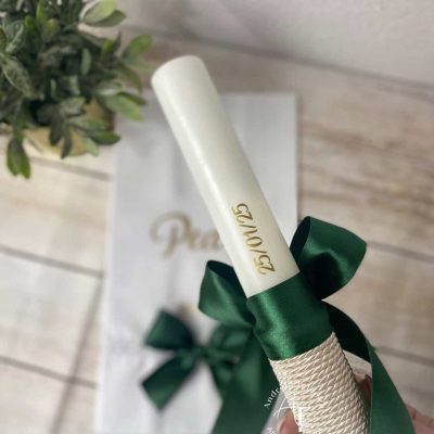 Vela de batizado personalizada com data em foil dourado, laço verde floresta e base revestida em cordão creme.